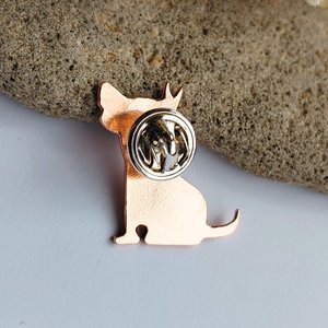 Rear view of the handcrafted copper dog brooch showing the brooch pin fastened