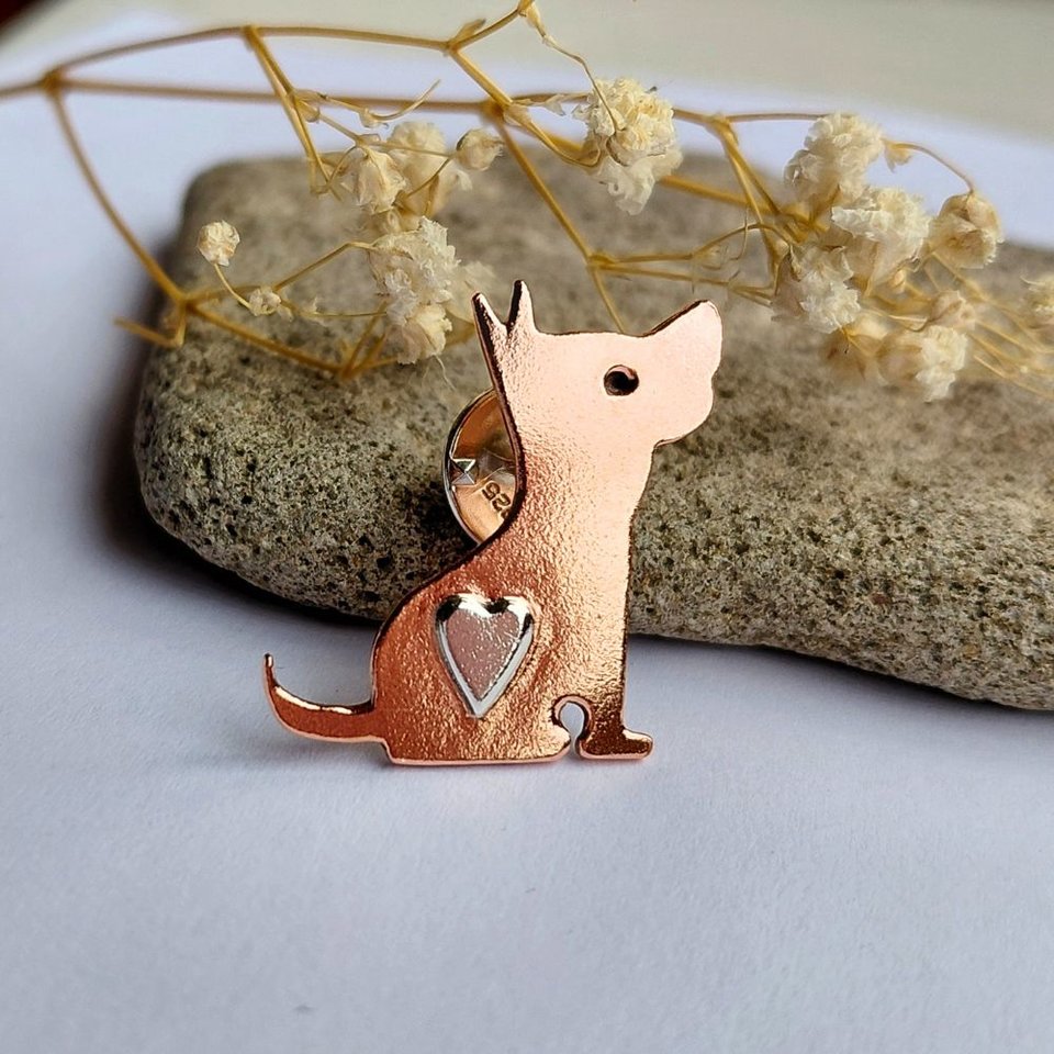 Angled view of the handcrafted copper dog brooch with a sterling silver heart