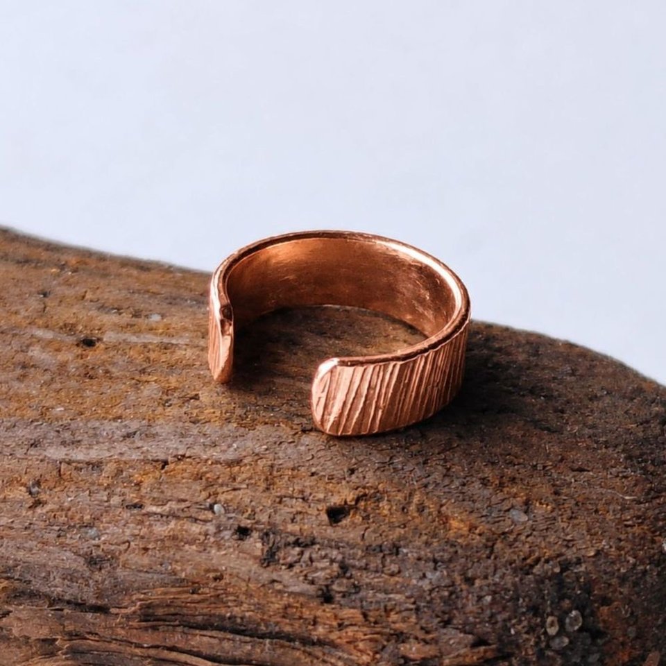Copper hammered ear cuff photographed from the side to show its curved open design